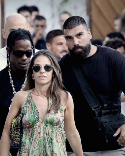 An Advanced VIP Services close protection officer walking a principal and his party out through a crowded lane in Mykonos