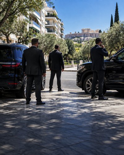 A close protection team standing by its vehicles outside an Athens residence