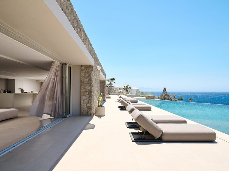 Sun loungers line the infinity pool where the water meets the open sea, Kalafatis