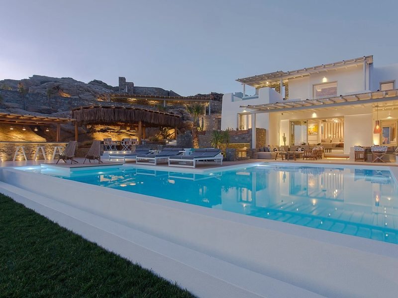 Infinity pool and sun loungers at dusk facing the open-sided living pavilion, Elia