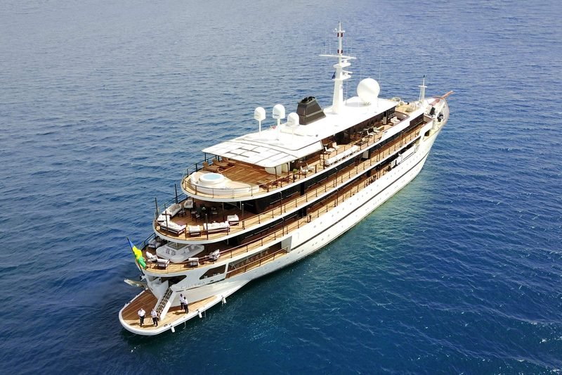 Aerial of the white motor yacht Chakra at anchor, tiered teak aft decks below