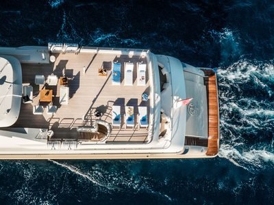 Aerial overhead of sun deck loungers, aft decks and teak transom underway