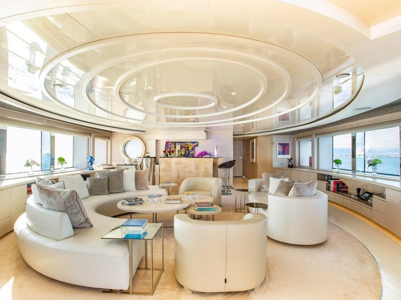 Main saloon with concentric gloss ceiling rings, white leather seating and bar aft