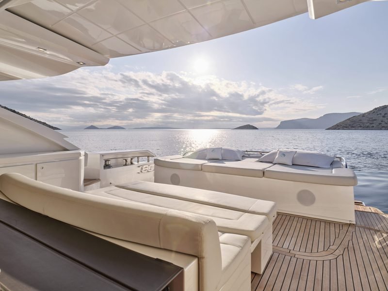 Aft cockpit sun pad and sofa under the hardtop, open sea beyond