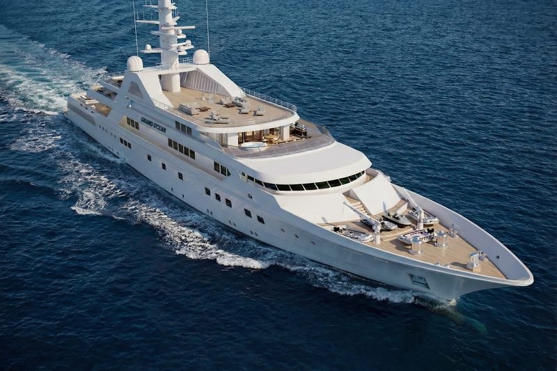 Aerial of the white motor yacht underway, name lettering visible on her superstructure