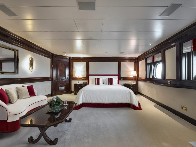 VIP cabin with red velvet headboard, white chaise and mirrored mahogany panelling