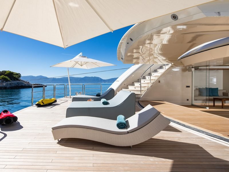 Aft sun deck with twin loungers, parasols and seabobs staged at the rail