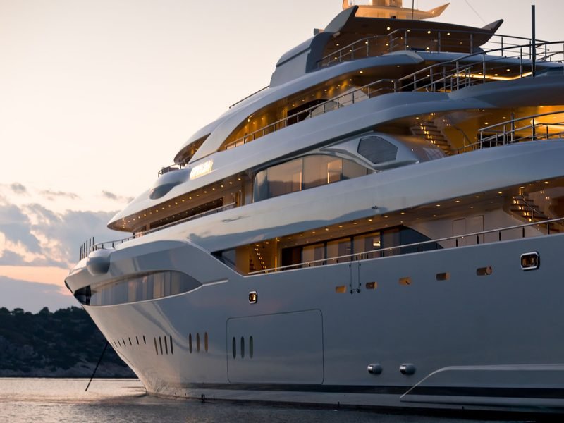 Bow quarter at dusk, layered decks glowing warm against a soft pink sky