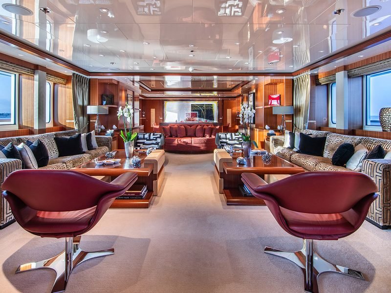 Main saloon with mahogany panelling, red leather swivel chairs and symmetrical facing sofas