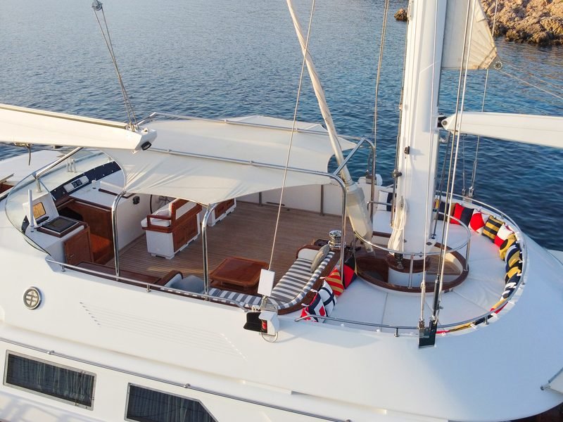 Aerial of the teak guest cockpit and helm station beneath its white sunshade